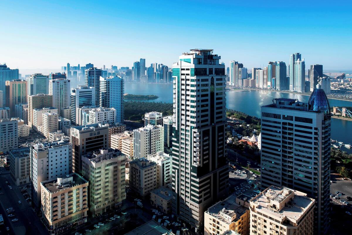 A high-rise urban area with modern buildings, a river, and a marina.
