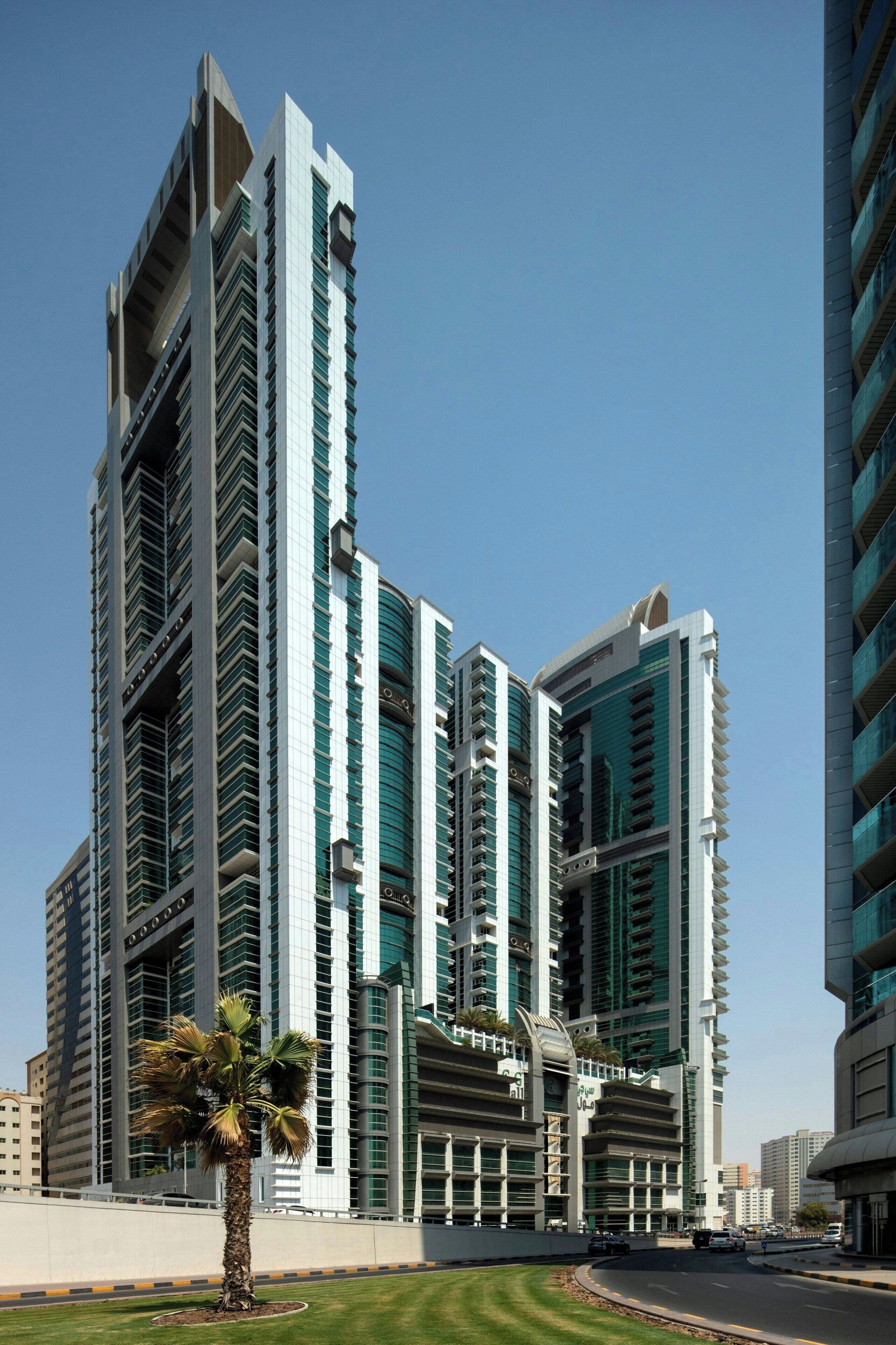 A modern high-rise building with multiple balconies and a central atrium.