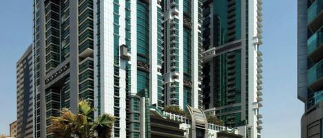 A modern high-rise building with multiple balconies and a central atrium.
