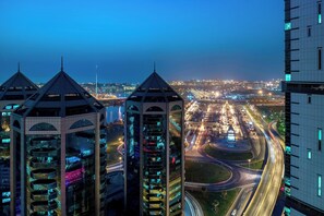 A high-rise building with multiple balconies and a view of a busy highway at dusk. - Four Points by Sheraton Sharjah (Sharjah)
