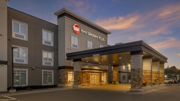 A Best Western Plus hotel with a modern design, featuring a covered entrance and stone accents. - Best Western Plus Isanti (Isanti)