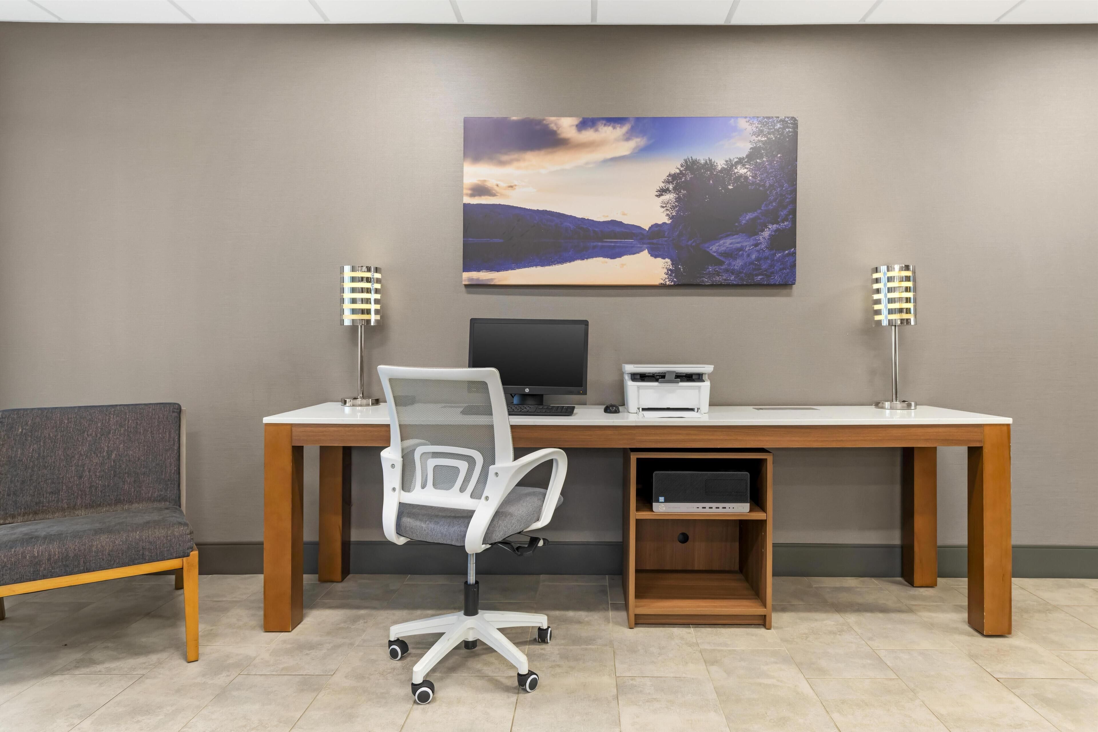 Un espacio de oficina moderno con escritorio, computadora y silla de oficina.