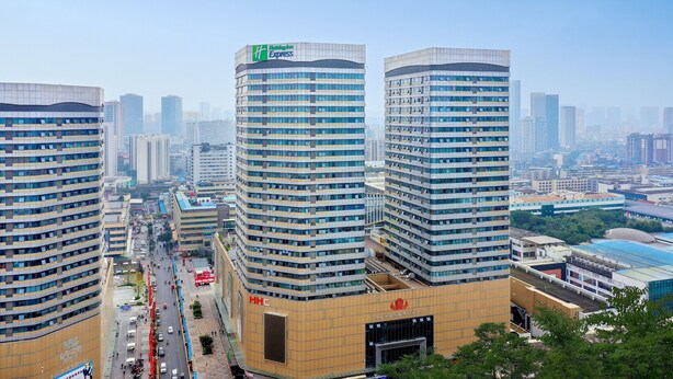 Un hotel de gran altura con varios pisos, amplias ventanas y un letrero llamativo de Holiday Inn Express.