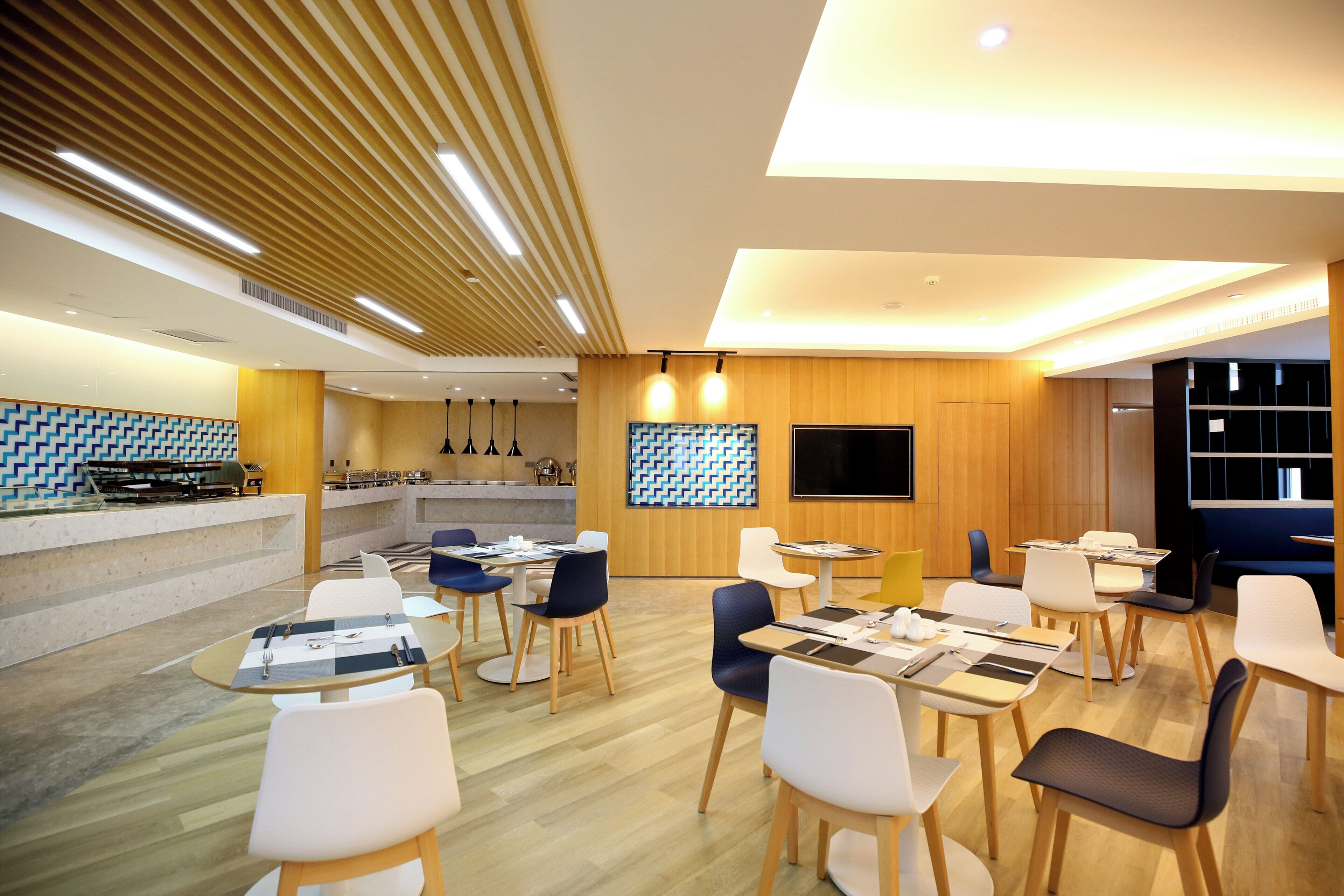 A modern restaurant with a central bar area, multiple dining tables, and a variety of seating options.