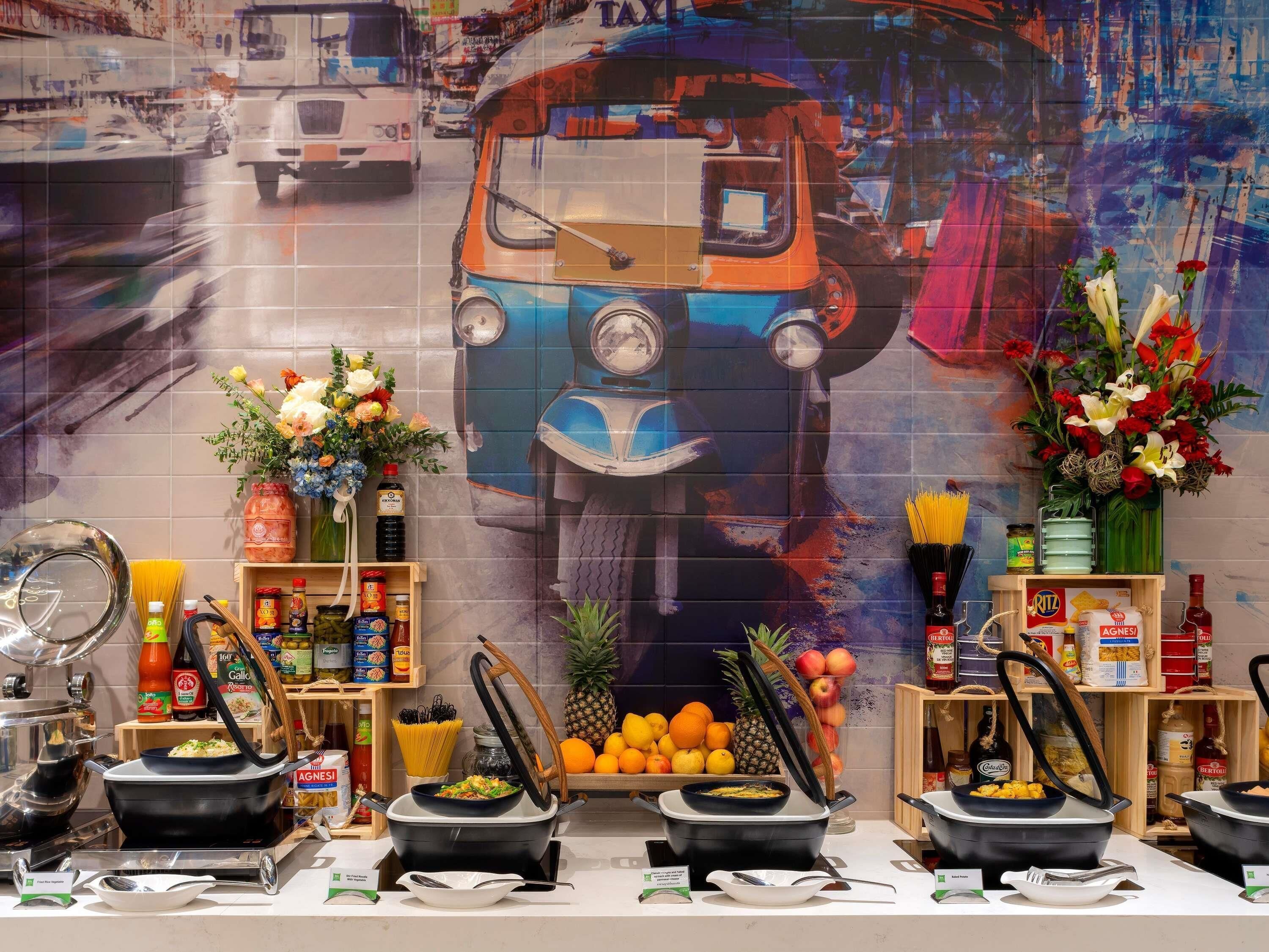 Un buffet avec plusieurs points de service, une grande fresque représentant un autobus, ainsi qu’une variété de plats et d’accompagnements.