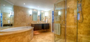 Enjoy a luxurious bathing experience with a bathtub and glass-enclosed shower.