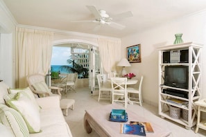 Relax in this spacious living area with a sofa, coffee table, and dining space, offering a view of the outdoors.