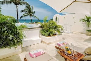 Relax in style with a hot tub, lounge chairs, and ocean views.