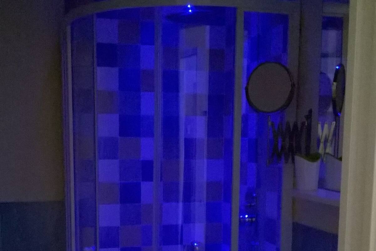 Un baño con cabina de ducha de vidrio, un lavabo y un espejo.