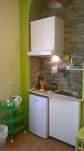 Estudio de diseñador, vista a la ciudad (Etnica) | Cocina privada | Refrigerador, microondas, parrilla de estufa y tetera eléctrica 