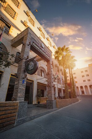 A building with a sign for "Al Qasr Coffee House" and a number "5" on the facade. - Grape Village Hotel (Amman)