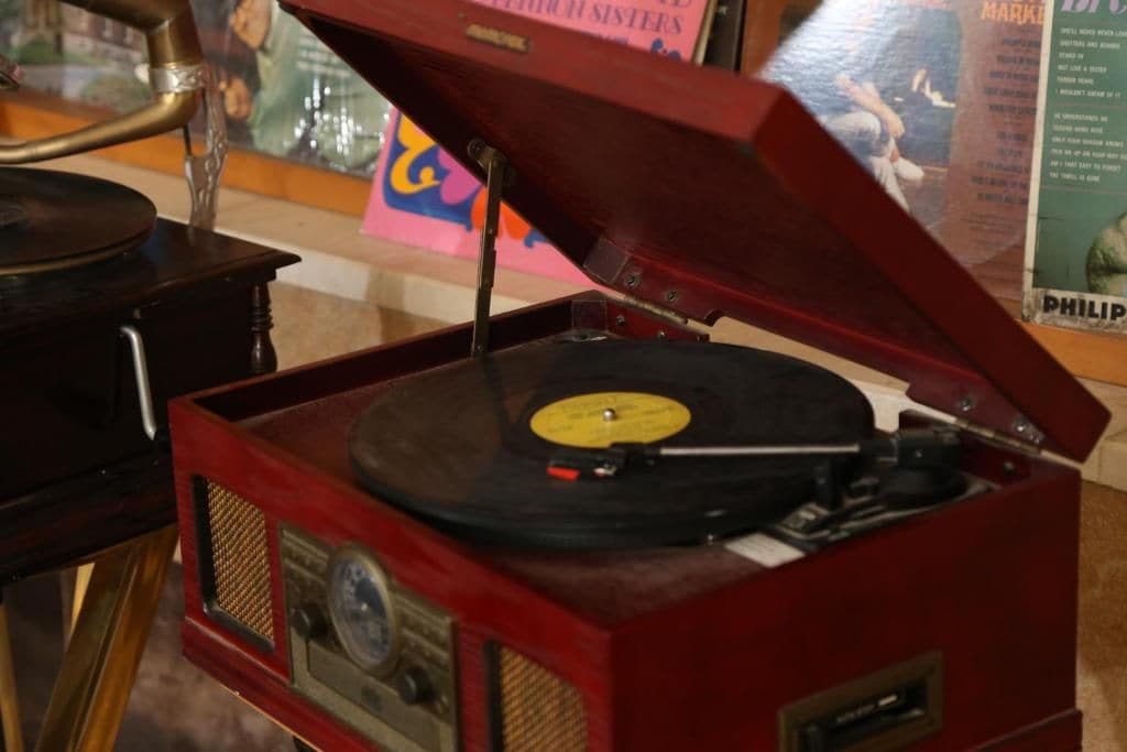 A vintage red record player with a turntable and a needle.