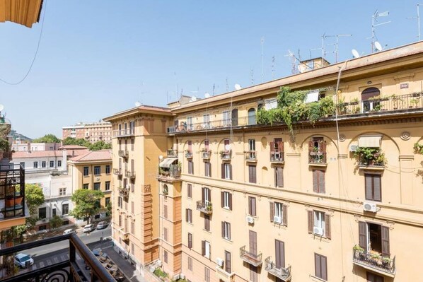 A multi-story building with balconies, air conditioning units, and a clear sky.