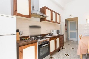 Una cocina compacta con estufa, horno, microondas y armarios de madera.
