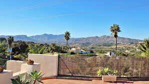 A terrace with a view of mountains, palm trees, and a fence. - El Ventorrillo - holiday home with stunning views and private pool in Benissa (Benissa)