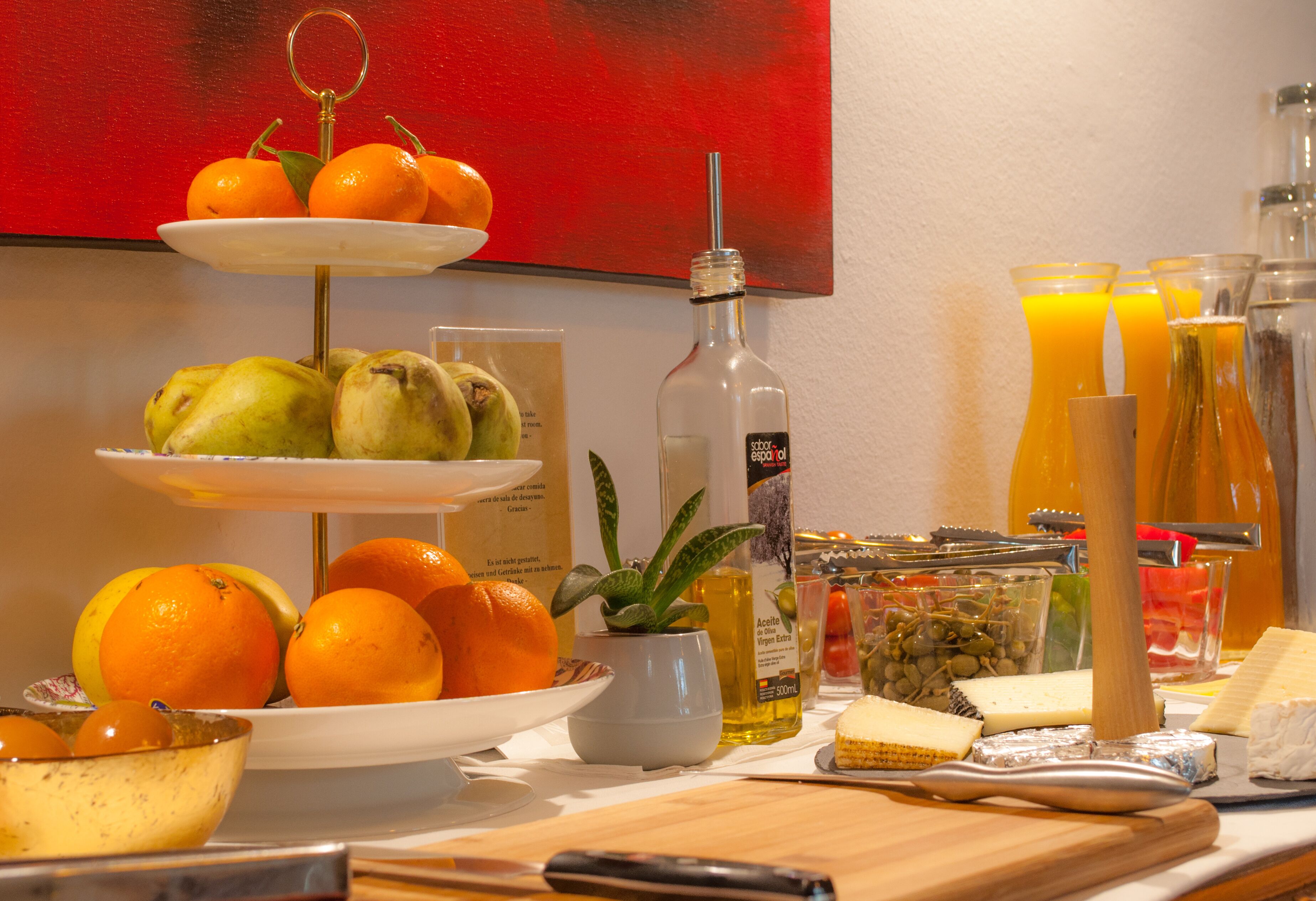 A breakfast buffet with fruits, cheese, and beverages.