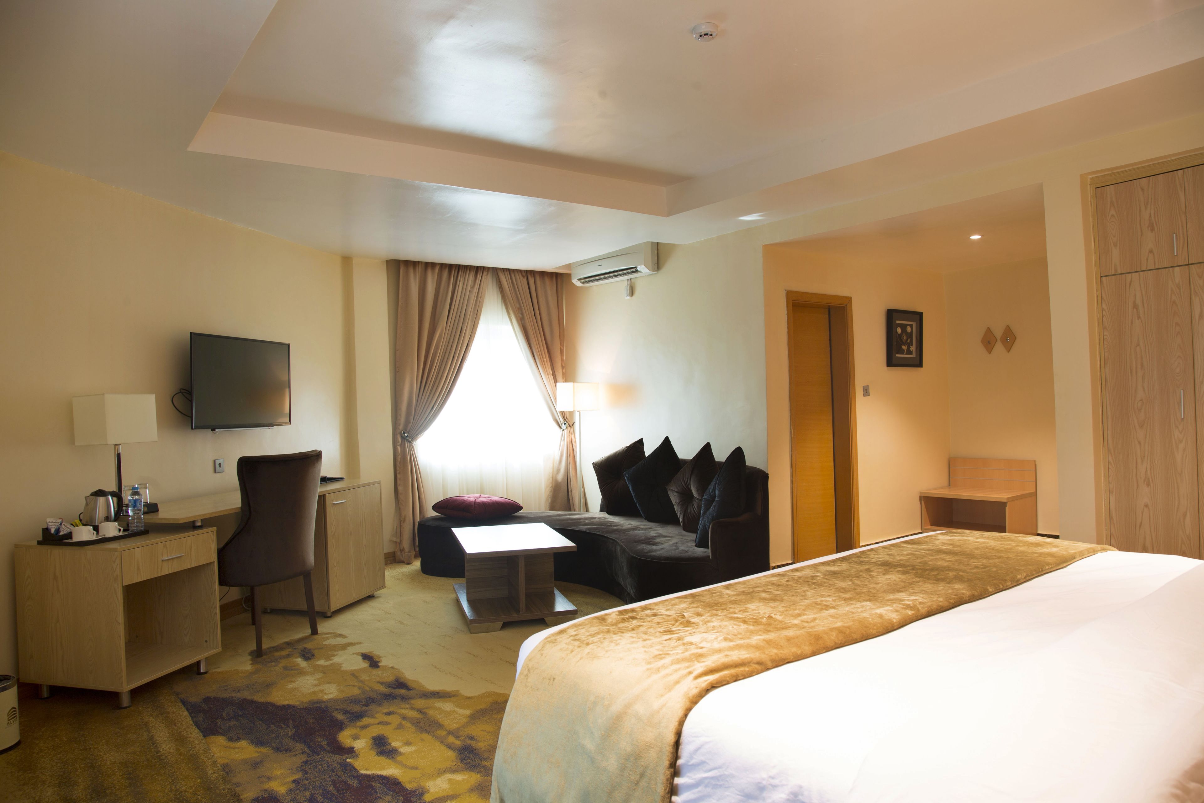 Ein Hotelzimmer mit Bett, Schreibtisch, Stuhl und Fernseher.