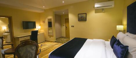 Una habitación de hotel con una cama, un escritorio, una silla y un televisor.