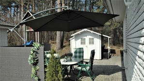 An outdoor patio with a table and chairs, a small Christmas tree, and a shed in the background. - Vacation cottage Albatros, Germany (Karlshagen)