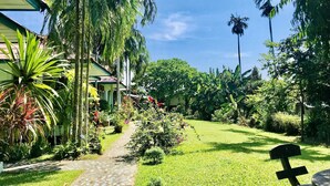Un rigoglioso giardino con un vialetto lastricato che conduce a un edificio con tetto in tegole.