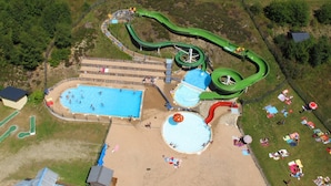 An aerial view of a water park with multiple pools, slides, and a tennis court. - VVF Les 7 Laux Massif de Belledonne, Prapoutel (Les Adrets)