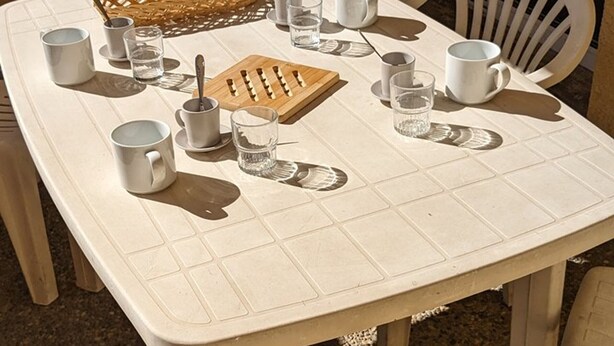 A white table with a grid pattern, surrounded by white chairs. - Cozy Studio for 4, Ski-In/Ski-Out, WiFi, Near Shops and Sports Center (Orcières Merlette)