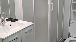 A modern bathroom with a white sink, a mirror, a shower enclosure, and a toilet. - Cozy Studio for 4, Ski-In/Ski-Out, WiFi, Near Shops and Sports Center (Orcières Merlette)