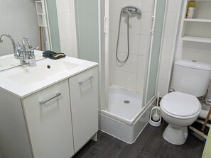 A bathroom with a shower, toilet, and sink.