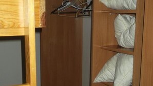 Ein Holzkleiderschrank mit mehreren Einlegeböden und Ablageflächen.