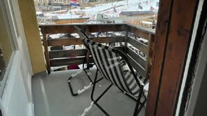 Un balcon avec vue sur une montagne enneigée et un drapeau.