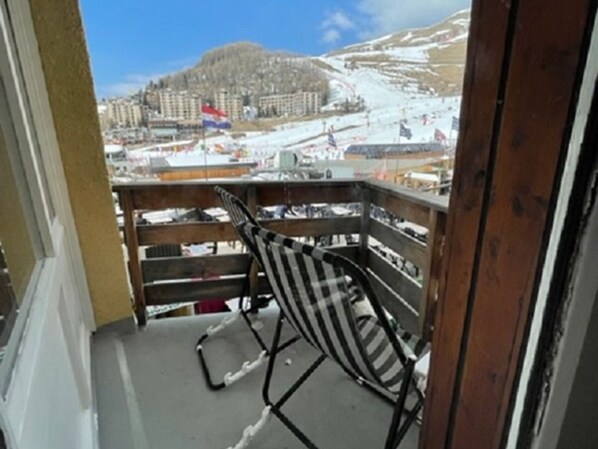 A balcony with a view of a snowy mountain and a flag.