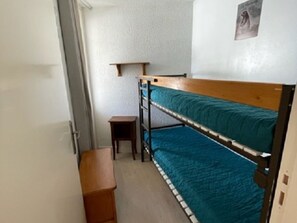 Cozy room with a bunk bed and simple furnishings.