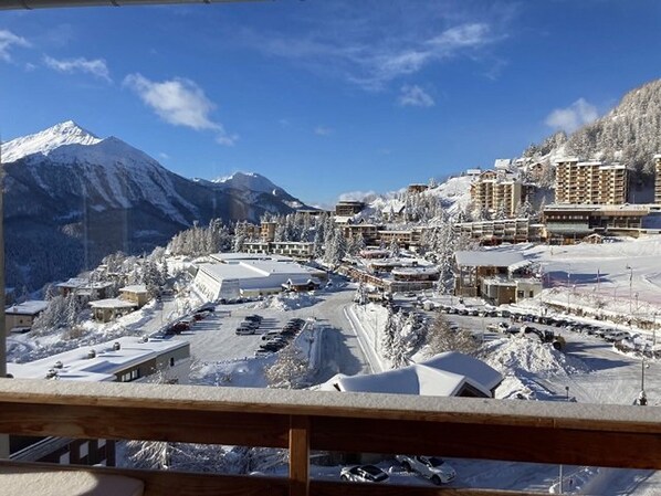 A snow-covered mountain town with buildings and a parking lot.
