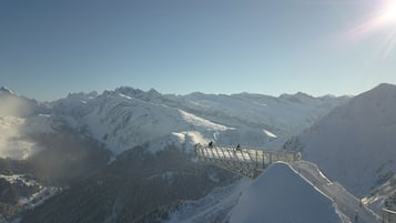 A snow-covered mountain landscape with a bridge and a clear sky.