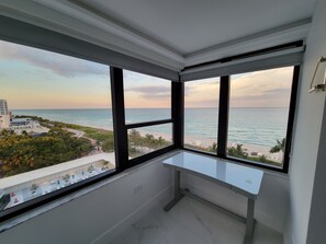 Una habitación con un amplio ventanal con vistas a una playa y al océano.