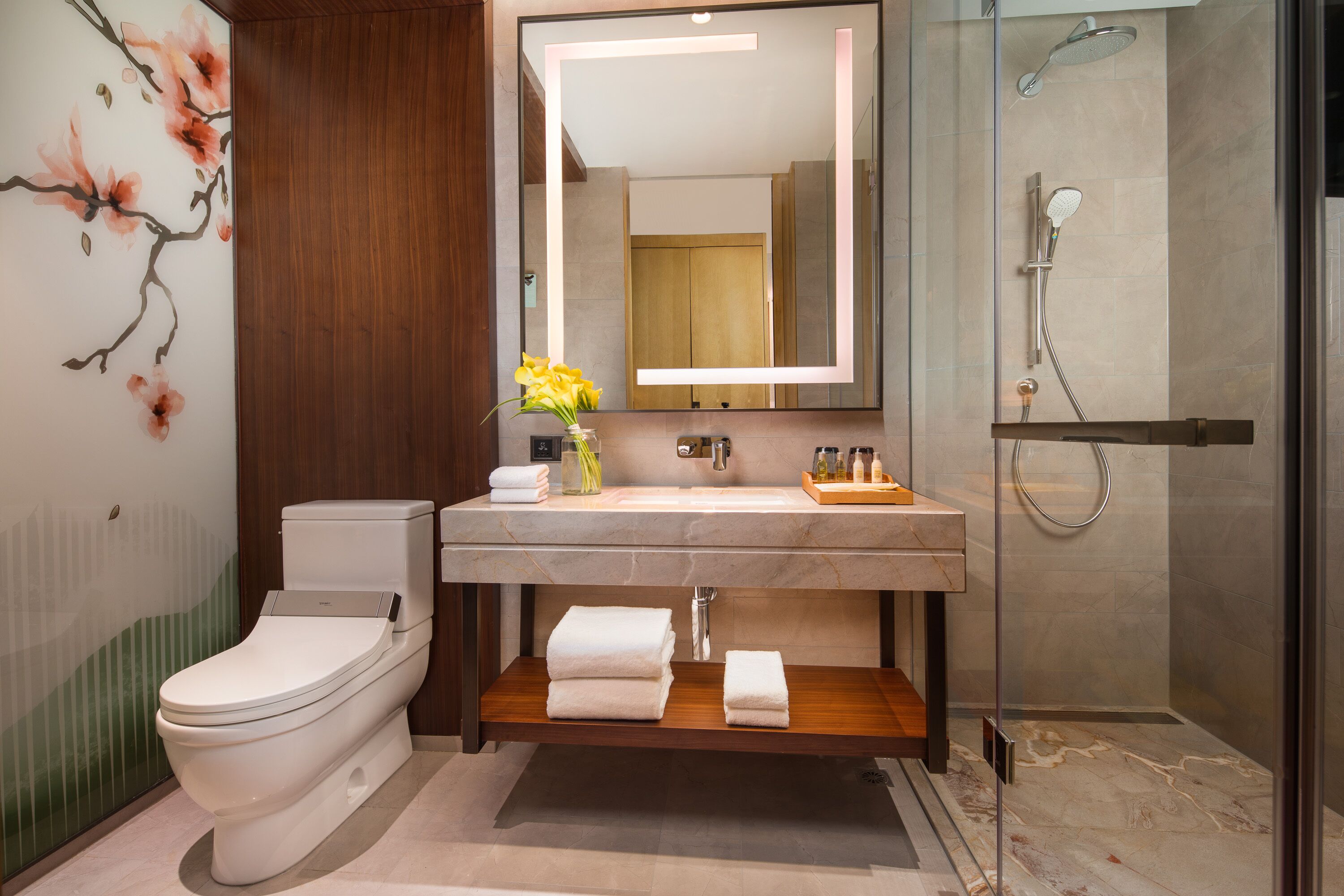 Een moderne badkamer met toilet, wastafel en douche.