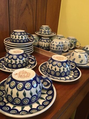 Una serie di set da tè in ceramica con decorazioni blu e bianche su un tavolo di legno.