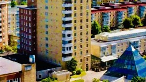 A high-rise building with multiple floors, surrounded by other residential buildings. - Golden Hostel (Jarfalla)