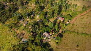 An aerial view of a residential area with houses, a swimming pool, and a red-roofed building. - Maili Saba Camp (Nakuru)