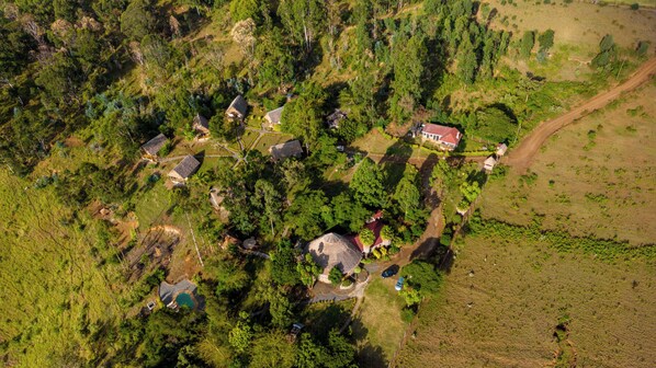 An aerial view of a residential area with houses, a swimming pool, and a red-roofed building. - Maili Saba Camp (Nakuru)