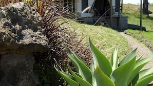 A rustic building with a thatched roof, a porch, and a small staircase leading to the entrance. - Maili Saba Camp (Nakuru)