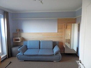 Una habitación moderna con sofá, mesita de noche y armario.