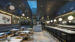 Ein modernes Restaurant mit Barbereich, Sitzgelegenheiten und einem Fischgrätenparkettboden.