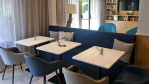 A seating area with a sofa and two tables, each with a candle holder.
