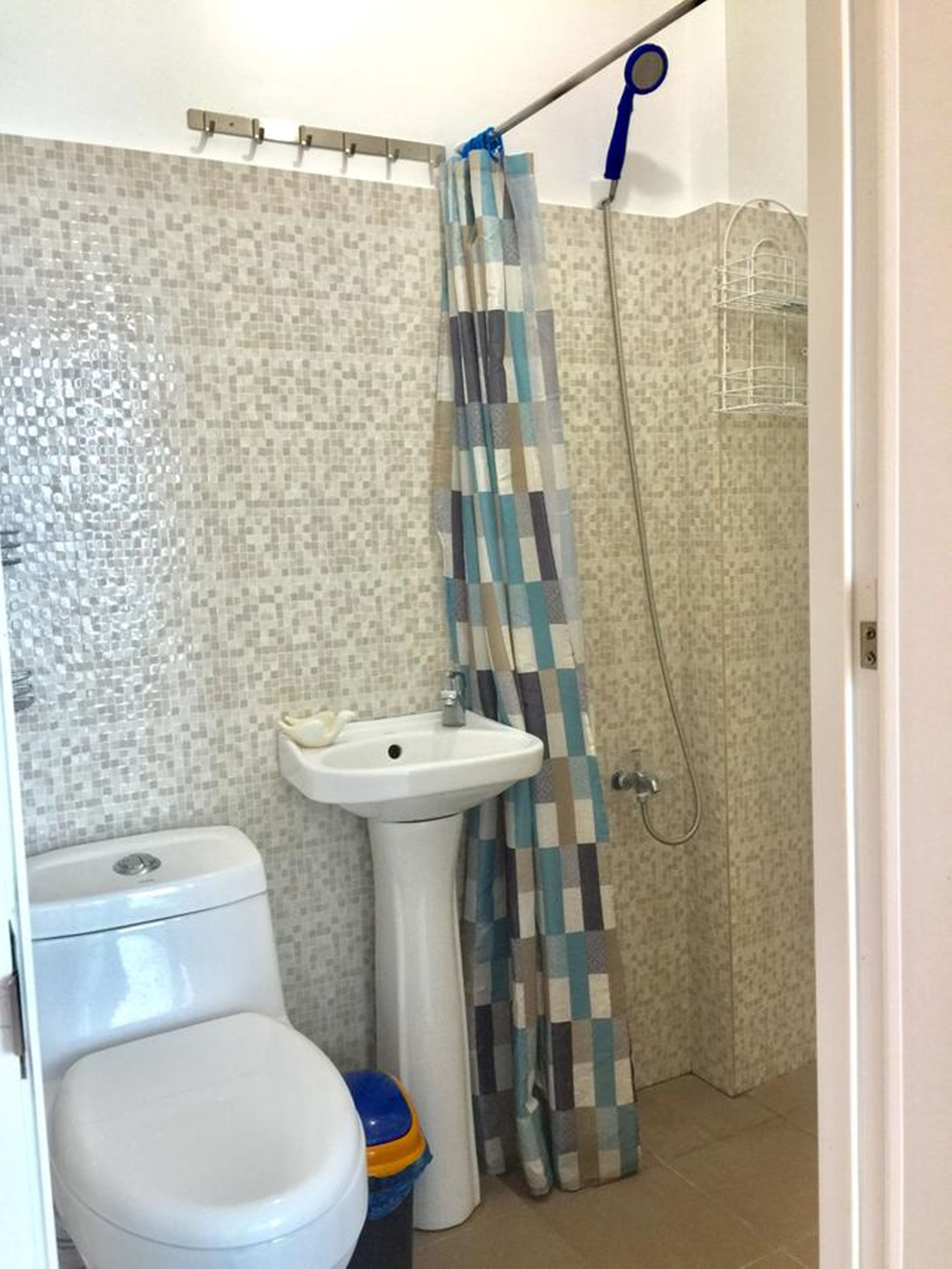A bathroom with a toilet, sink, and shower.
