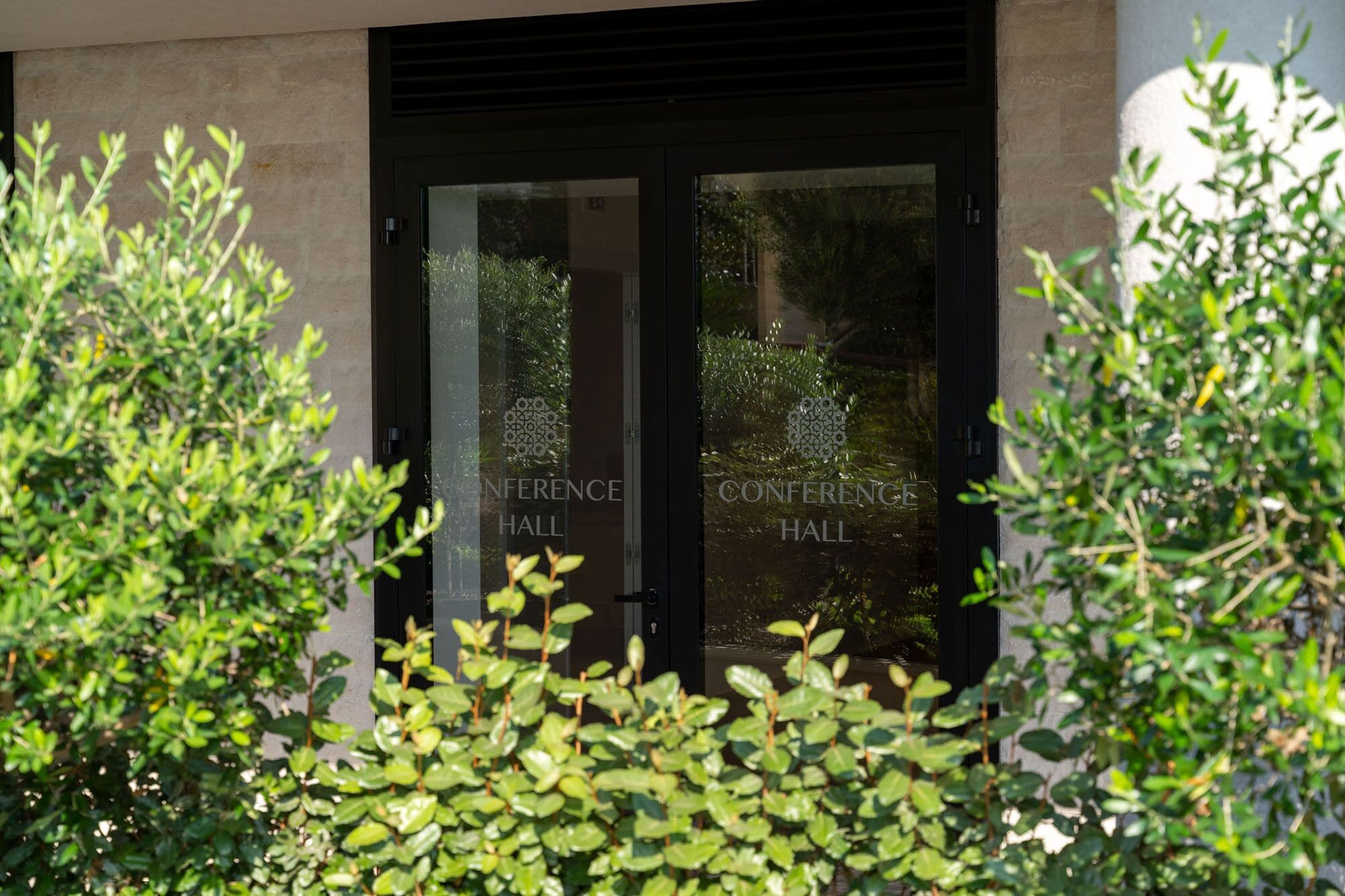 A building entrance with two glass doors labeled "Conference Hall".