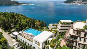 A coastal hotel with a swimming pool, multiple balconies, and a view of the sea. - Hotel Harmonia by Dukley (Budva)