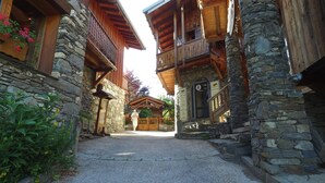 A traditional stone building with wooden balconies and a gravel pathway leading to a wooden door. - VVF La Plagne Montchavin Paradiski (La Plagne-Tarentaise)