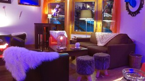 A cozy living room with a sofa, ottomans, a coffee table, and a lamp. - VVF La Plagne Montchavin Paradiski (La Plagne-Tarentaise)