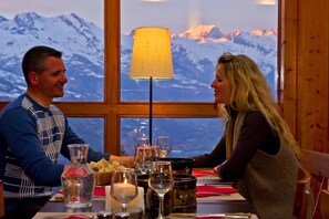 A dining table with a mountain view, a lamp, and various dishes and glasses. - VVF La Plagne Montchavin Paradiski (La Plagne-Tarentaise)